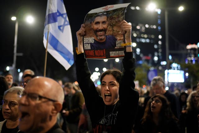 Families and supporters of Israeli hostages held by Hamas in Gaza hold their photographs and shout slogans at a rally calling for their return, in Tel Aviv, Israel, on Saturday