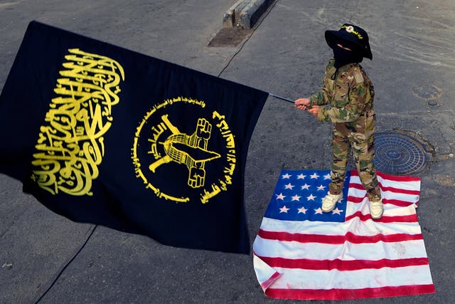 A child waves the Palestinian Islamic Jihad group flag as she stands on an American flag during a protest in solidarity with the Palestinian people in Gaza, at Bourj al-Barajneh Palestinian refugee camp, in Beirut, Lebanon, on Sunday